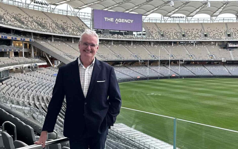 Former Australian television presenter Tim Gossage standing on the sidelines of a stadium.